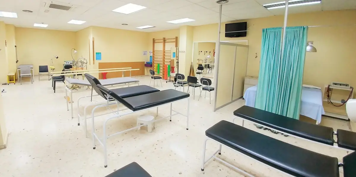 Gimnasio de rehabilitación de la clínica, con camillas, paralelas y espalderas